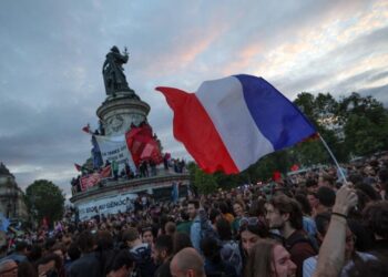 BENDERA Perancis dikibarkan semasa perhimpunan malam pilihan raya Parlimen di Place de la Republique, pada 7 Julai.-AFP