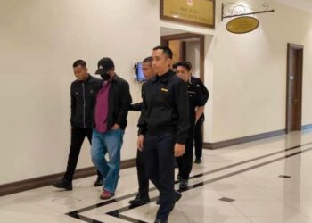 TERTUDUH (dua kiri) diiring keluar oleh pegawai SPRM di Mahkamah Khas Rasuah di Kota Kinabalu hari ini.