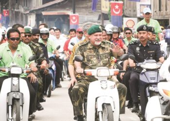 Sultan Ibrahim Sultan Iskandar menunggang motosikal sambil  bermesra dengan  rakyat ketika Kembara Mahkota Johor di Bekok, Segamat, pada tahun 2016. – MINGGUAN/RAJA JAAFAR ALI