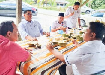 JEFRIDIN Atan (tiga dari kanan) menikmati durian bersama beberapa ketua kampung bagi mendengar masalah penduduk di Pekan Penerok, Pontian, Johor.