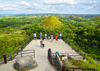 PENGUNJUNG menikmati pemandangan di Bukit Coklat, yang terletak di tengah Pulau Bohol, di Filipina.- AGENSI