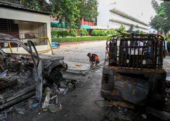 KESAN kenderaan yang dibakar oleh peserta protes di Dhaka. -AFP