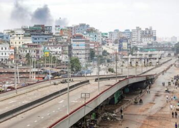 KEPULAN asap kelihatan dari bahagian belakang kejiranan pinggir selatan Dhaka ketika pertembungan meletus antara polis dan penunjuk perasaan antikuota di Dhaka, Bangladesh. – AFP