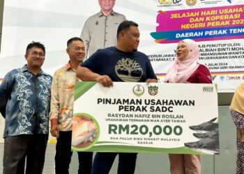 SALBIAH Mohamed (kanan) menyampaikan Pinjaman Usahawan Perak SADC pada Jelajah Hari Usahawan dan Koperasi Negeri Perak 2024 di Seri Iskandar di Parit hari ini. - UTUSAN/LIYANA RAMLI