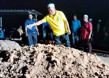 ABDUL Wahab Ariffin menyiram air di kubur adiknya di Tanah Perkuburan Islam Telok Medan di Bagan Serai hari ini. - UTUSAN/WAT KAMAL ABAS