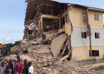 ORANG ramai berkumpul di sebelah bangunan sekolah yang runtuh di Jos, pada Jumaat.- AGENSI
