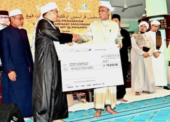 SYED Ibrahim Syed Ahmad (kanan) menyampaikan replika cek kepada Aizuddin Hakim Mohd Yusof di Masjid Jengka 18, Maran baru-baru ini. – UTUSAN/ SHAIKH AHMAD RAZIF