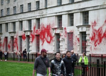 ORANG ramai berjalan di hadapan bangunan Kementerian Pertahanan yang disimbah dengan cat merah sewaktu rusuhan anti-Islam yang berlaku di London, baru-baru ini. - AFP