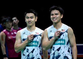 GOH Sze Fei (kanan) dan Nur Izzuddi bergambar di podium selepas kemenangan mereka menentang pemain Korea Selatan, Kang Min-hyuk dan Seo Seung-jae semasa perlawanan akhir beregu lelaki kejohanan badminton Terbuka Jepun di Arena Yokohama. - AFP