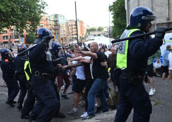 ANGGOTA polis berhadapan kumpulan anti pendatang yang merusuh di Bristol, UK.- AFP