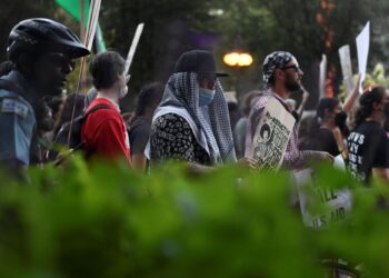 ORANG ramai memegang papan tanda semasa protes untuk menuntut menuntut gencatan senjata di Gaza pada malam Konvensyen Kebangsaan Demokratik (DNC) di United Center di Chicago, Illinois, pada 18 Ogos 2024.-AFP