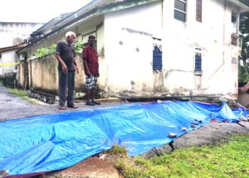 E. PAUL Subramaniam (kanan) menunjukkan keadaan tanah runtuh yang berlaku di Taman Sri Pinang, Port Dickson sejak Jumaat lalu.