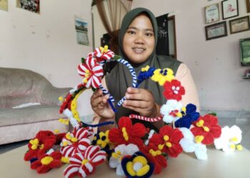 SITI Nur Natrah Yatimi Mohd. Azmi menunjukkan gubahan cekak bunga raya di Kampung Gong Duek, Besut, Terengganu, semalam. 
– UTUSAN/WAN ZURATIKAH IFFAH WAN ZULKIFLI