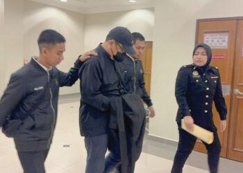 YAP Kim Heng (memakai pelitup muka)  ketika dihadapkan ke Mahkamah Sesyen Kuantan, Pahang, semalam. – UTUSAN/NORHAFIZAN ZULKIFLI