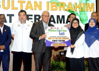 NOORAZAM Osman menyampaikan hadiah tempat pertama kepada SMK (P) Sultan Ibrahim (SIGS) yang memenangi kategori Sekolah Showcase sempena Program Pendidikan Kelestarian LA21. - UTUSAN/RAJA JAAFAR ALI