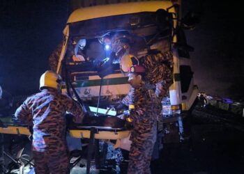 ANGGOTA bomba berusaha mengeluarkan mangsa yang tersepit di tempat duduk pemandu.