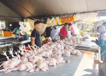 MOHD. Adam Mukhriz (kanan) melayan pelanggan di kedai ayamnya di Kampung Gong Pauh, Kuala Terengganu, semalam. – MINGGUAN/TENGKU DANISH BAHRI TENGKU YUSOFF