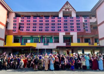 MURID dan guru bergambar bersama Jalur Gemilang gergasi yang dihasilkan sendiri di Sekolah Kebangsaan (SK) Bintong, Kangar, Perlis, hari ini. - UTUSAN/ASYRAF MUHAMMAD