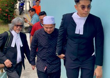 EBIT Lew (tengah) diiringi peguam, Ram Singh dan Mohd. Syarulnizam Salleh Keruak semasa tiba di pekarangan Mahkamah Majistret Tenom, hari ini.