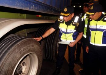 STIEN Van Lutam (kiri) menunjukkan tayar sebuah lori yang berada dalam keadaan tidak selamat ketika operasi bersepadu di Plaza Tol Jitra, Kubang Pasu.