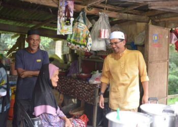 MOHD. Azmawi Fikri Abdul Ghani (kanan) rancak berbual dengan salah penduduk semasa berkempen di Kawasan DUN Nenggiri, Gua Musang, Kelantan.