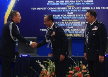 RAZARUDIN Husain (tengah) bersalam dengan Muhamad Zaki Harun semasa Majlis Serah Terima Tugas Pemangku Ketua Polis Kelantan di Pejabat Polis Kontinjen (IPK) Kelantan, Kota Bharu, Kelantan hari ini-UTUSAN/KAMARUL BISMI KAMARUZAMAN.