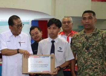 MOHAMED KHALED NORDIN (kiri) menyerahkan sumbangan komputer riba sempena  pelancaran program e-Perkasa SPM Yayasan Lembaga Tabung Angkatan Tentera (LTAT) di Kem Mahkota di sini, hari ini.