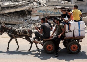 PENDUDUK bersama kotak bantuan yang disediakan oleh Agensi Bantuan dan Pekerjaan Pertubuhan Bangsa-Bangsa Bersatu untuk Pelarian Palestin (UNRWA) di Gaza.-AFP