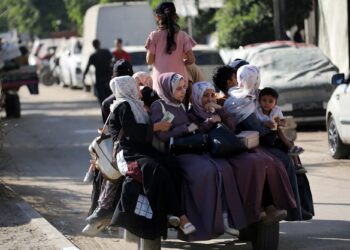 WANITA Palestin dan kanak-kanak cuba menyelamatkan diri ekoran serangan Israel terhadap kawasan Deir Al-Balah, Gaza, kelmarin.-AFP