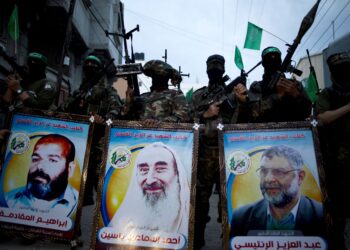 ANGGOTA Briged Al-Qassam memegang plakad potret pemimpin Hamas, Abdel Aziz Rantissi (kanan), Sheikh Ahmed Yassin (tengah) dan Ibrahim Muqadmeh semasa perhimpunan pada 23 Mac 2016 di Gaza.- AFP