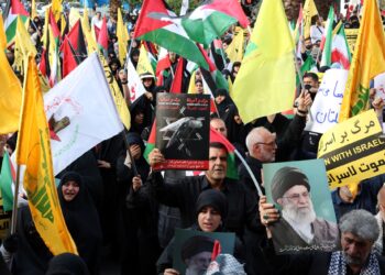 RAKYAT Iran mengibarkan bendera Palestin dan memegang sepanduk mengecam pembunuhan Ismail Haniyeh dalam protes di dataran Palestin di Teheran, kelmarin.- AFP