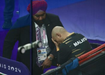 TIMBALAN Presiden Persekutuan Kebangsaan Berbasikal Malaysia (PKBM) Datuk Amarjit Singh menenangkan Azizulhasni selepas disingkirkan aksi pusingan pertama keirin lelaki.- IHSAN FB MSN