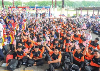 Pelajar berbilang kaum mengibarkan Jalur Gemilang sempena Sambutan Bulan Kebangsaan  dan Ulang Tahun ke-30 SMK Taman Universiti, Johor Bahru, semalam. – UTUSAN/RAJA JAAFAR ALI