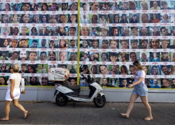 ORANG ramai melalui jalan yang memuatkan poster gambar-gambar 
rakyat Palestin yang dijadikan tebusan oleh tentera Israel di Gaza sejak serangan pada 7 Oktober lalu. -AFP