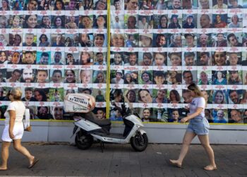 ORANG ramai melalui jalan yang memuatkan poster gambar-gambar 
rakyat Palestin yang dijadikan tebusan oleh tentera Israel di Gaza sejak serangan pada 7 Oktober lalu. -AFP