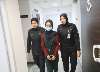 AIMI Shairah Ismail (tengah) dibawa keluar dari Mahkamah Majistret Kuala Terengganu, semalam selepas menghadapi pertuduhan mencuri dua helai baju minggu lalu. – UTUSAN/TENGKU DANISH BAHRI TENGKU YUSOFF