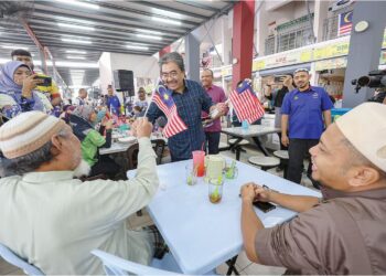 JOHARI Abdul Ghani mengagihkan Jalur Gemilang kepada orang ramai selepas pelancaran Konvoi Kembara Merdeka di Pasar Wirawati, Titiwangsa, semalam.