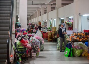 SEORANG peniaga mengemas kedai cenderahati yang mula dibuka di Pasar Kedai Payang I di Kuala Terengganu, hari ini. - UTUSAN/PUQTRA HAIRRY ROSLI