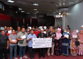 ARIFFIN Deraman (depan, tengah) bergambar bersama sebahagian usahawan yang menerima surat tawaran pinjaman perniagaan di Kuala Terengganu, hari ini. - UTUSAN/KAMALIZA KAMARUDDIN