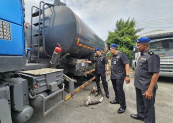 SAHARUDDIN Mohd Kia (kanan) memeriksa tangki sebuah lori yang ditahan dalam Ops Tiris 3.0 di Kawasan Perindustrian Chendering, Kuala Terengganu, hari ini. - UTUSAN/PUQTRA HAIRRY ROSLI