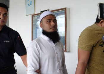 TERTUDUH diiring anggota polis ketika dihadapkan ke Mahkamah Sesyen, Ayer Keroh, Melaka atas pertuduhan melakukan amang seksual fizikal terhadap remaja perempuan berusia 14 tahun. - UTUSAN/SYAFEEQ AHMAD