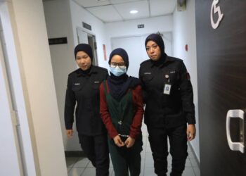 AIMI Shairah Ismail (tengah) yang dituduh mencuri dua helai baju di sebuah pusat membeli-belah dibawa keluar dari Mahkamah  Majistret Kuala Terengganu, hari ini. - UTUSAN/TENGKU DANISH BAHRI TENGKU YUSOFF