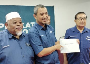 SAHRUDDIN Jamal (tengah) bersama Abdullah dan Teo Kok Chee (kanan) menunjukkan sampul yang mengandungi senarai tiga nama calon selepas mesyuarat PN di Pejabat Bersatu Kluang di Taman Saujana, Kluang.