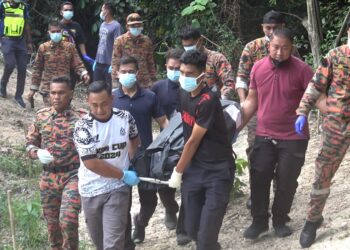 PASUKAN penyelamat mengusung mayat lelaki tanpa identiti yang ditemukan di kawasan belukar di Kampung Bukit Chatak, Dungun, petang tadi. - UTUSAN/NIK NUR IZZATUL HAZWANI NIK ADNAN