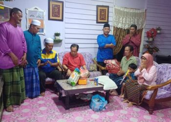 AHMAD Maslan (tengah) bermesra dengan keluarga Hamsan Tukiman ketika Program Ziarah kasih di Kampung Parit Madirono, Benut, Pontian.