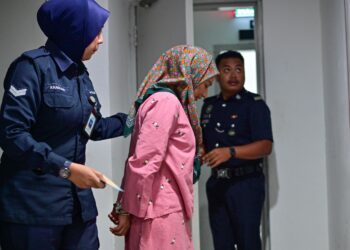 ENI Nooryanie Mohamad (tengah) yang mengaku salah membuat hantaran jelik di aplikasi TikTok dibawa keluar dari Mahkamah Sesyen Kuala Terengganu, hari ini. - UTUSAN/PUQTRA HAIRRY ROSLI