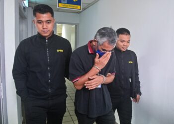 JAFRI Wahab (tengah) yang didakwa atas 13 tuduhan pecah amanah dan memalsukan dokumen  dibawa keluar dari Mahkamah Sesyen Kuala Terengganu hari ini. - UTUSAN/PUQTRA HAIRRY ROSLI