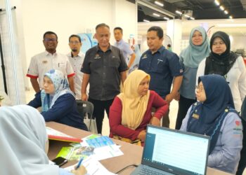 FARIHAH Che Husin (duduk, kanan) beramah mesra dengan seorang pengunjung di Karnival Kerjaya MyFutureJobs 2024 di Kuala Terenggan, hari ini. - UTUSAN/KAMALIZA KAMAUDDIN