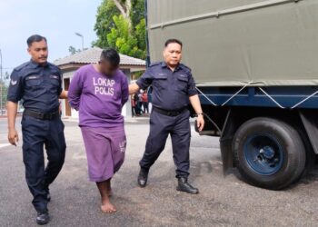 SALAH seorang suspek diiringi anggota polis ketika dibawa ke Mahkamah Majistret, Jasin, Melaka untuk permohonan reman. - UTUSAN/MUHAMMAD SHAHIZAM TAZALI