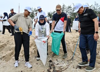 TENGKU Muhammad Ismail Sultan Mizan Zainal Abidin (kiri) dan Ahmad Samsuri Mokhtar (kanan) mengutip sampah pada  Majlis Perasmian Pembersihan Pantai Batu Buruk, Kuala Terengganu, hari ini. - UTUSAN/PUQTRA HAIRYY ROSLI